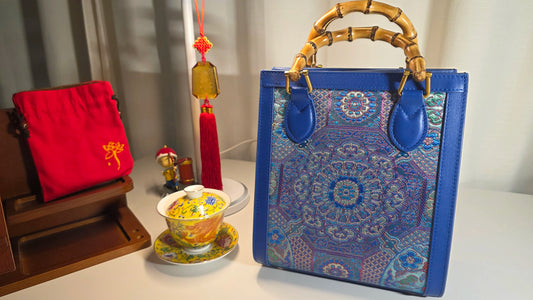ARC Bamboo Midnight Sapphire Brokat-Handtasche in dekorativem Wohnambiente mit Bambusgriffen und detailreichem Brokatgewebe in Blau- und Türkistönen