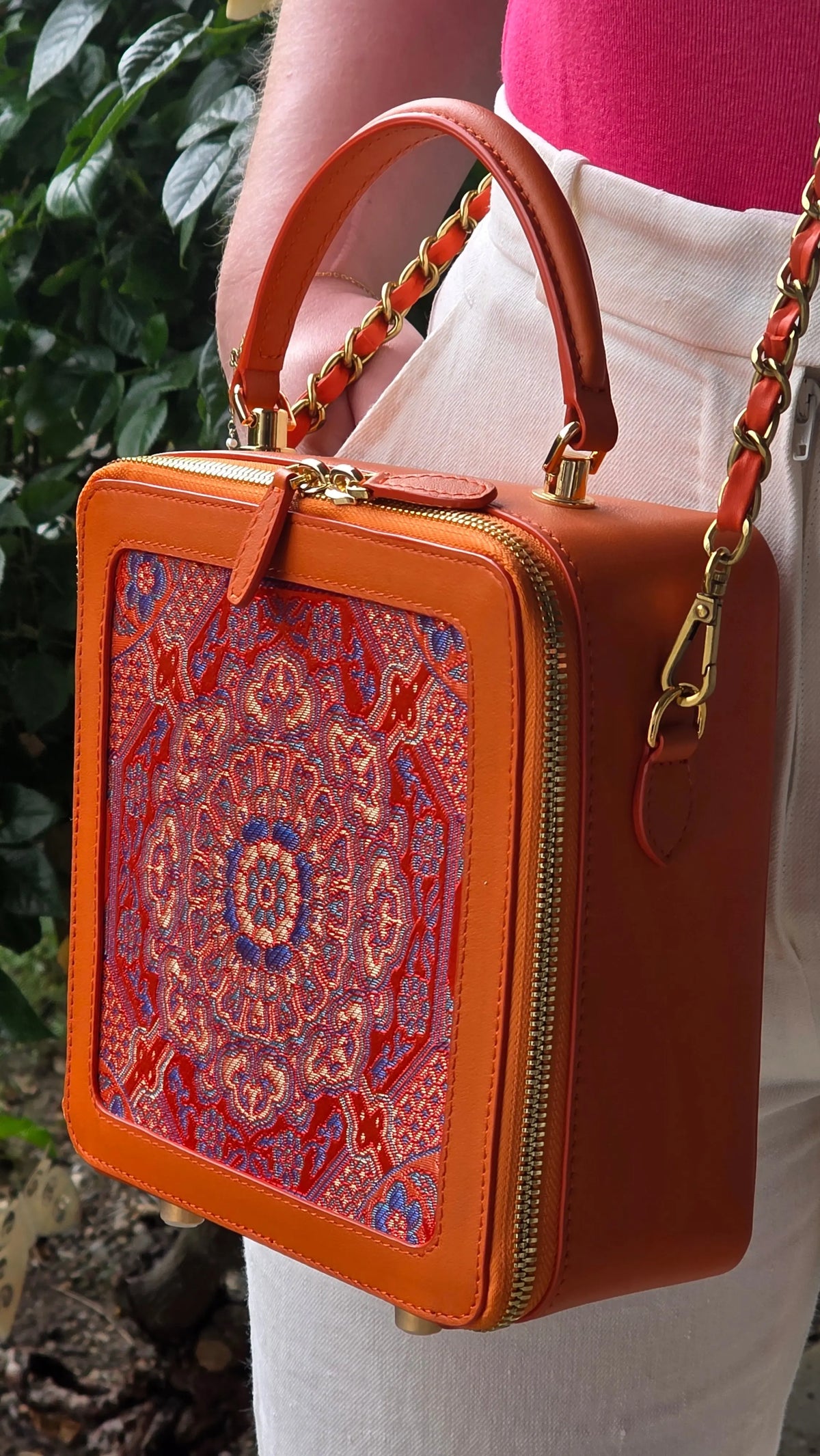 Detailaufnahme der Brokatstruktur und der geometrischen Mandala‑Stickerei in warmen Orangetönen. Sichtbar sind die hochwertige Verarbeitung, die Textur des Leders und die feinen handgefertigten Elemente der Guangdong‑Manufaktur.