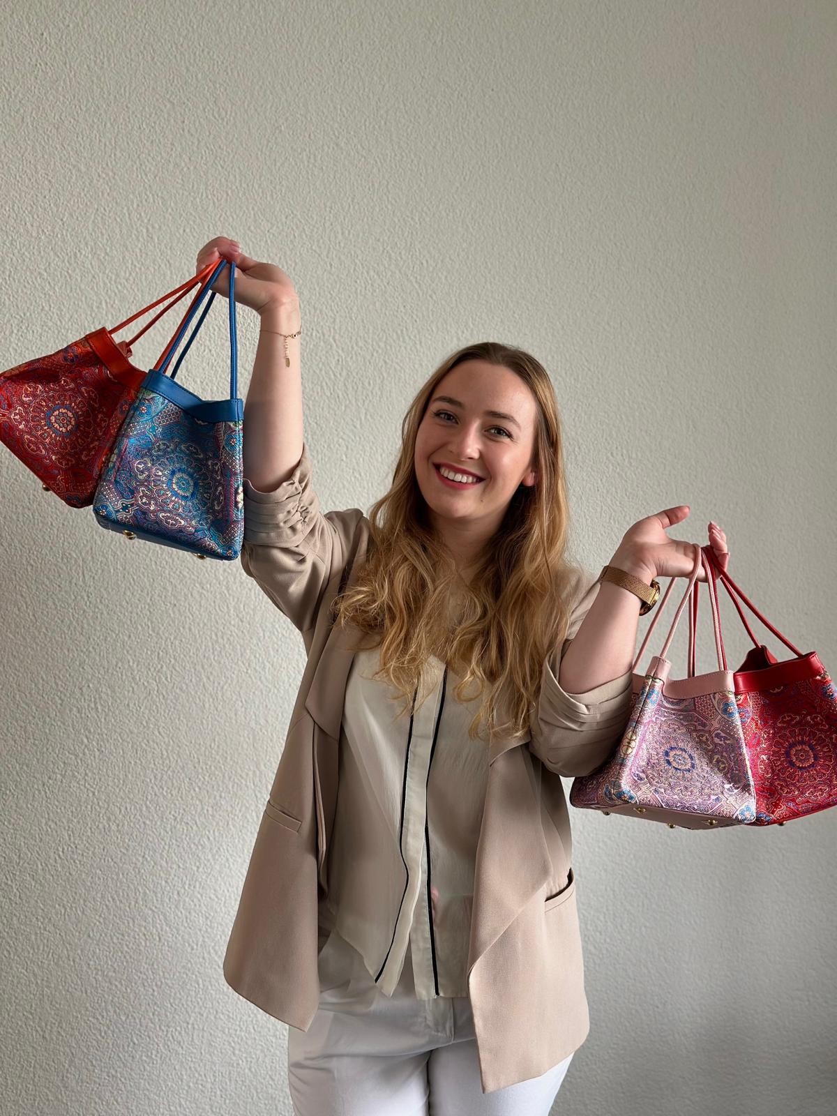 Sinodreams – Markenbotschafterin präsentiert handgefertigte Brokat‑Taschen mit Bambusgriff und feiner Ledernaht, Symbol für asiatische Meisterkunst, Schweizer Präzision und modernen Luxus mit Seele.
