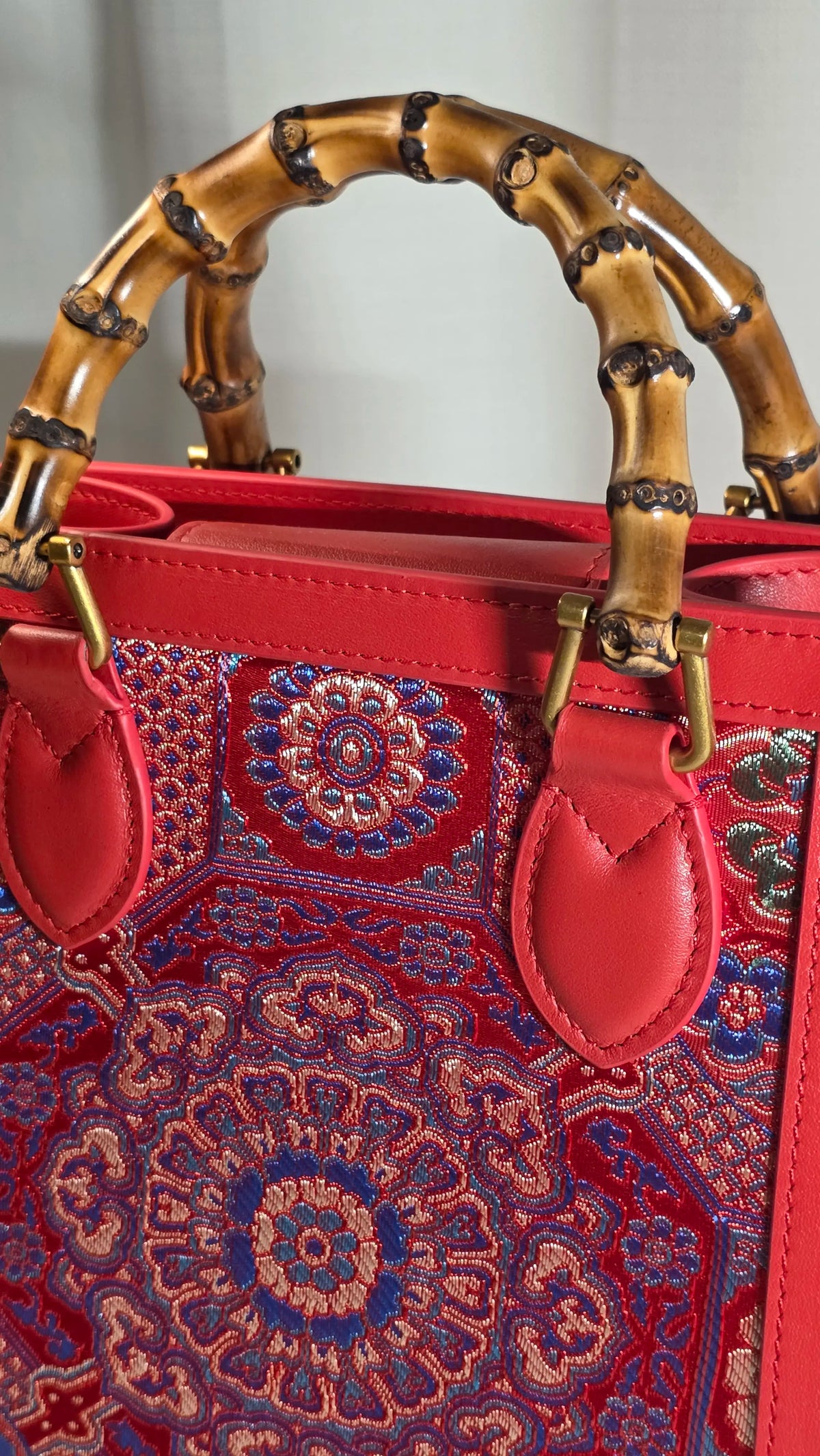 Frontalansicht der ARC Bamboo Imperial Scarlet mit detailreichem orientalischem Brokatmuster und natürlichem Bambusgriff