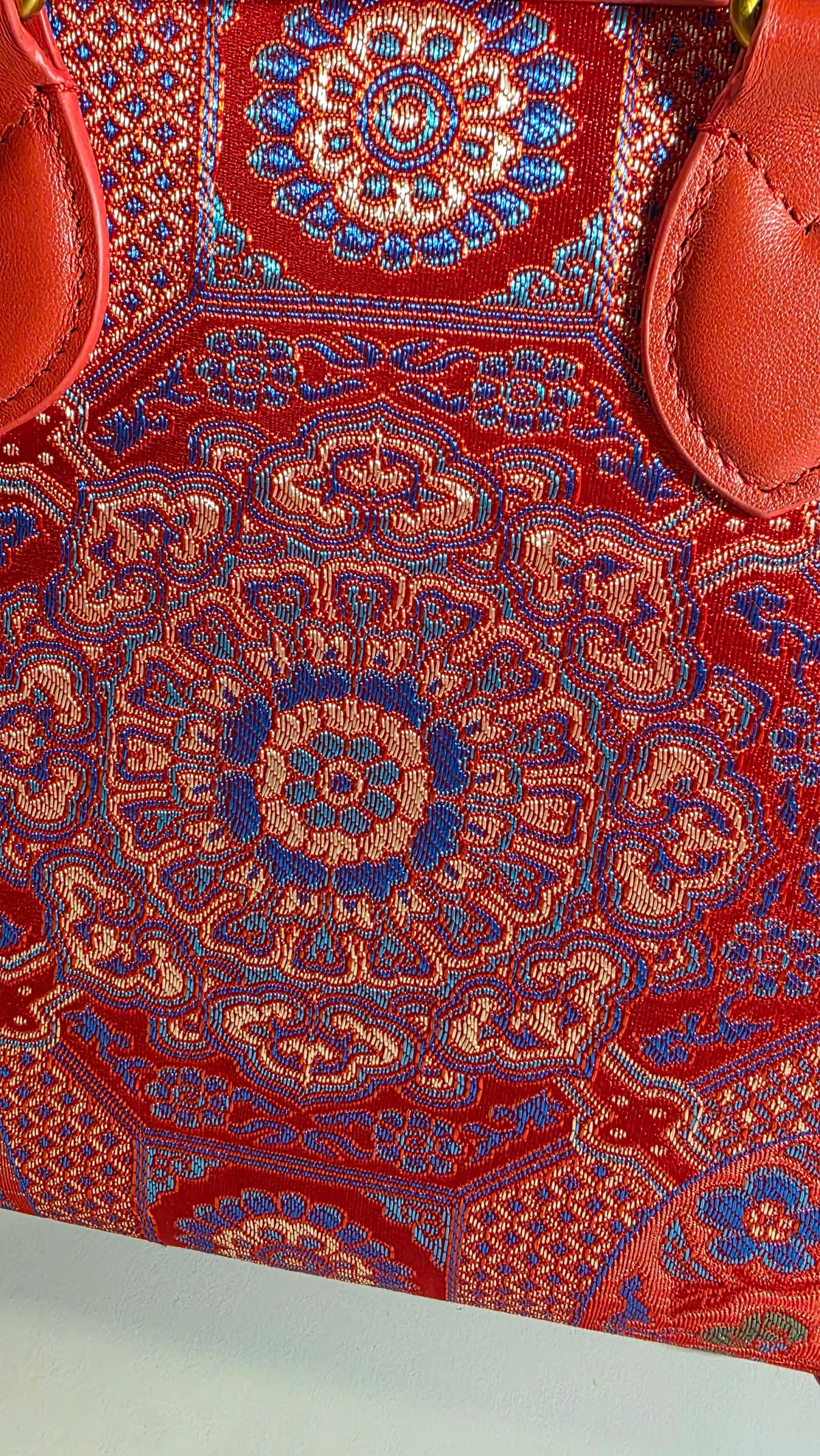 Detailaufnahme des aufwendig gewebten Brokatstoffs der ARC Bamboo Imperial Scarlet mit ornamentalen Mustern in Rot, Blau und Gold