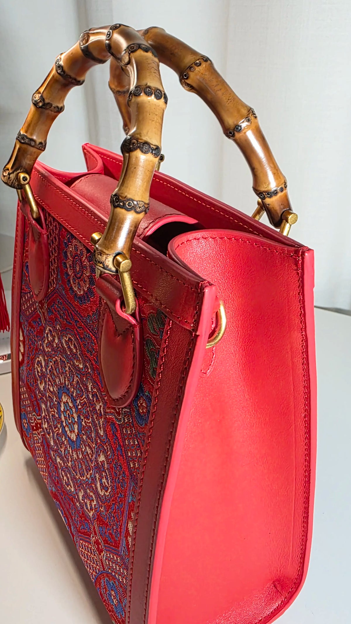Seitenansicht der ARC Bamboo Imperial Scarlet mit strukturierter Silhouette, roten Seitenflächen und charakteristischem Bambusgriff