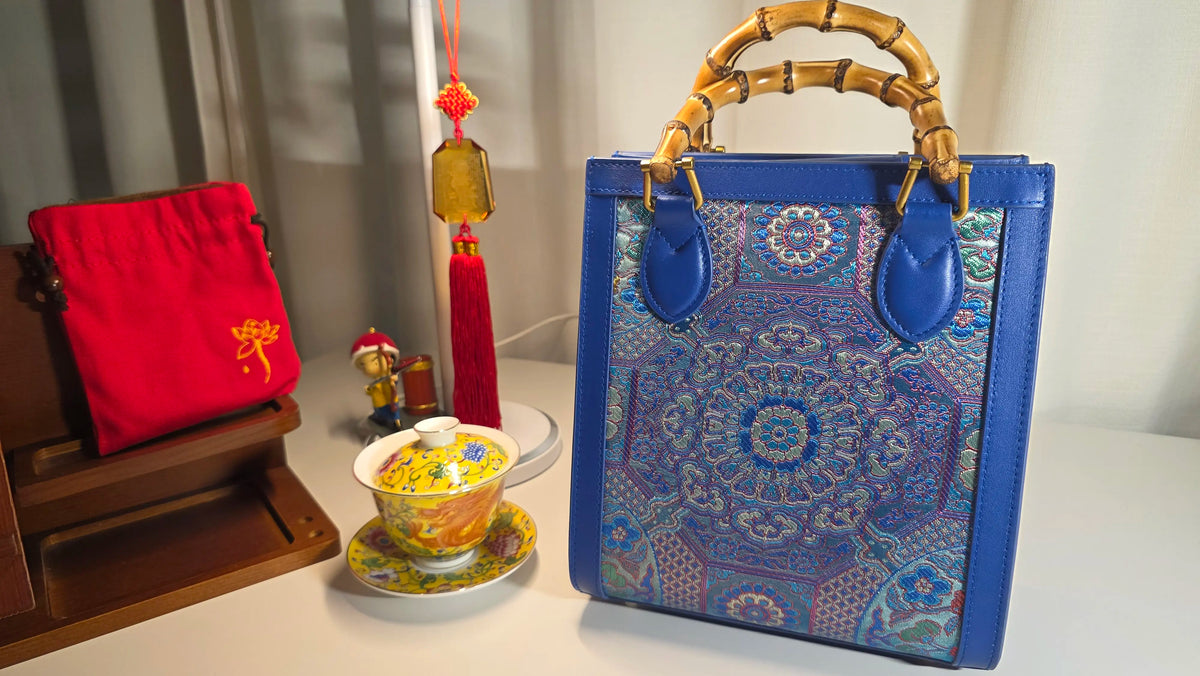 ARC Bamboo Midnight Sapphire Brokat-Handtasche in dekorativem Wohnambiente mit Bambusgriffen und detailreichem Brokatgewebe in Blau- und Türkistönen