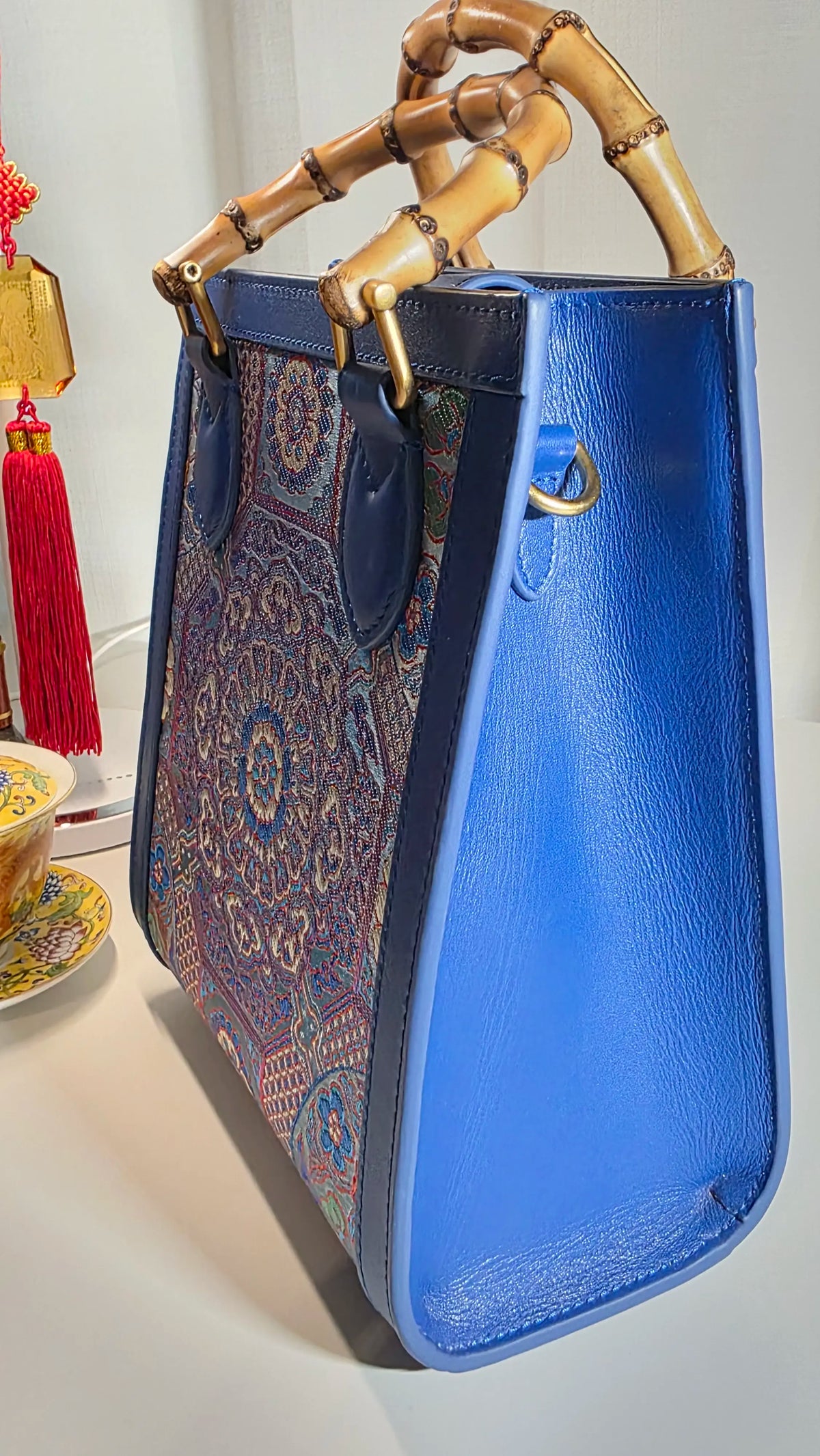 Seitenansicht der ARC Bamboo Midnight Sapphire mit saphirblauen Lederseiten, strukturierter Form und handverarbeiteten Bambusgriffen