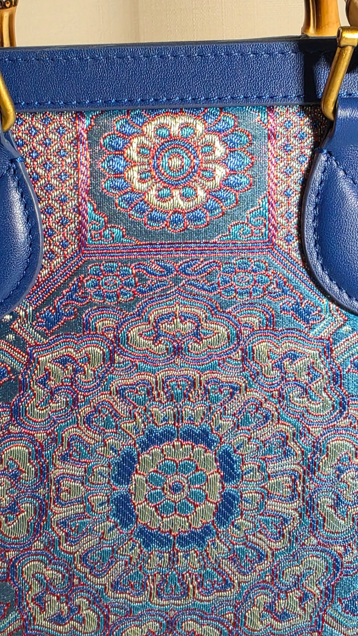 Detailaufnahme des kunstvoll gewebten Brokatmusters der ARC Bamboo Midnight Sapphire mit saphirblauen, türkisen, korallfarbenen und silbernen Ornamenten