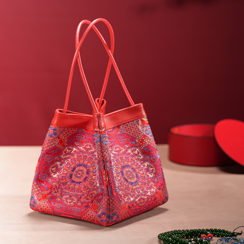 Phoenix Arc Bag – rote Brokat‑Handtasche mit goldenen und blauen Musterdetails, handgefertigt in familiärer Guangdong‑Manufaktur.