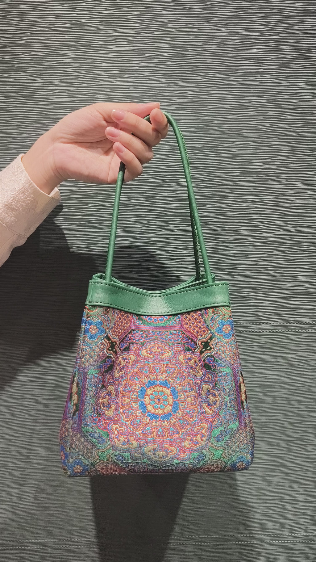 sinodreams jade harmony brokat-handtasche mit blau violett rot gold details und jadegrünem leder an der arc-silhouette video back ansicht